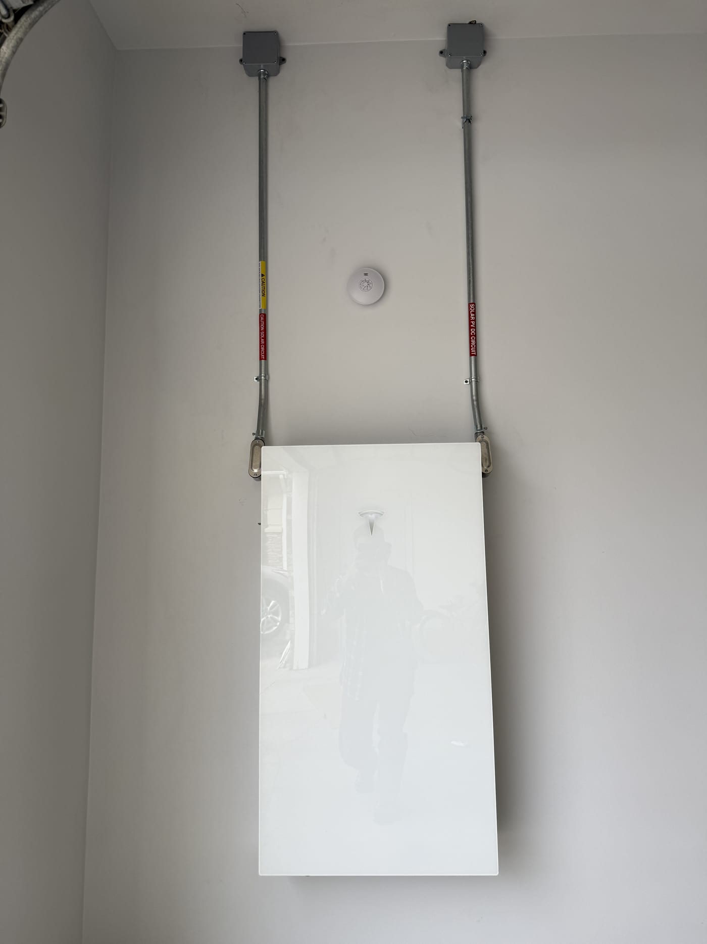 Wide shot of Tesla Powerwall 3 setup with junction boxes and conduit