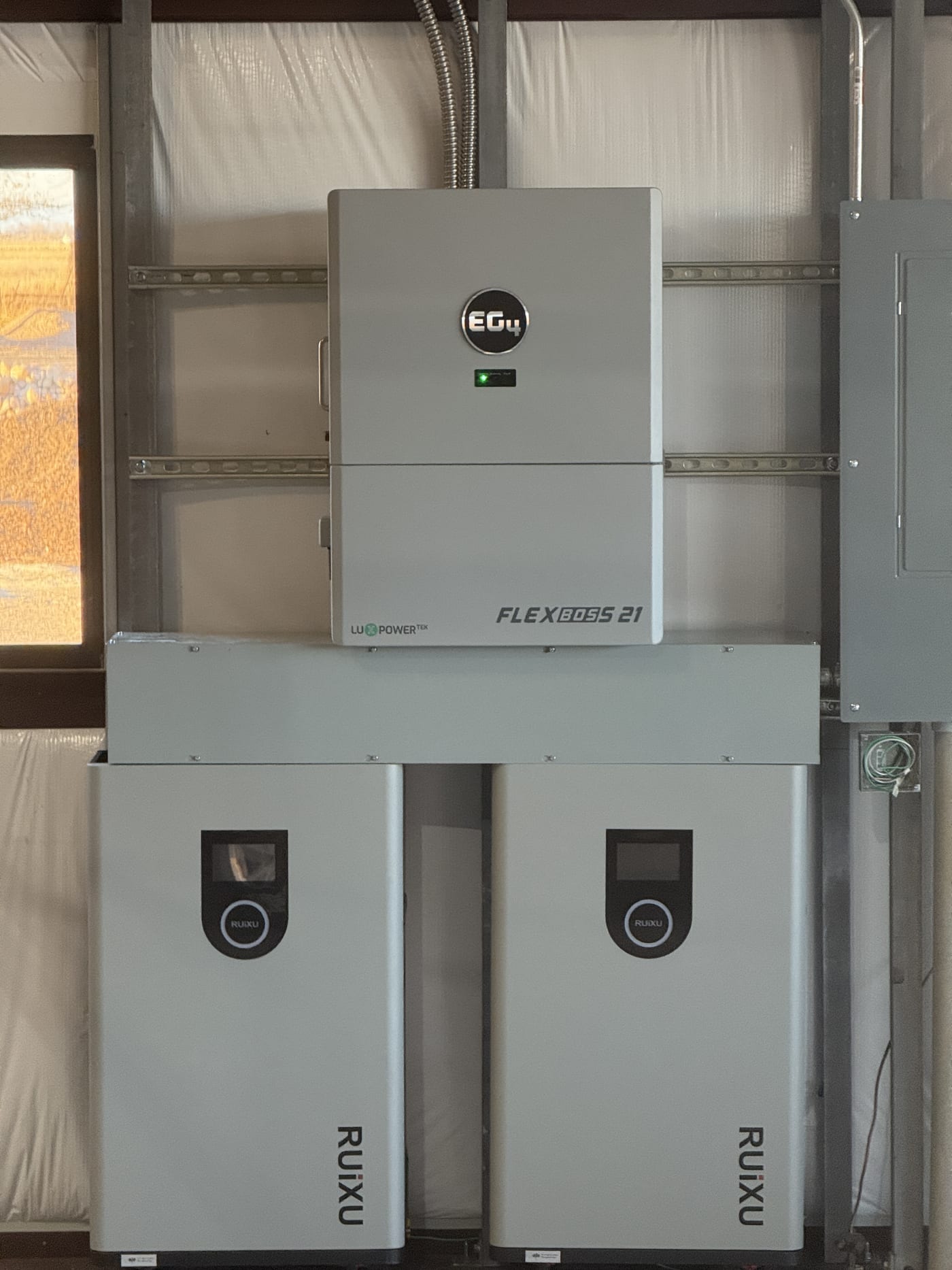 Close-up of EG4 FlexBOSS 21 inverter with two RUiXU battery units, green LED on inverter, brand logos clearly visible
